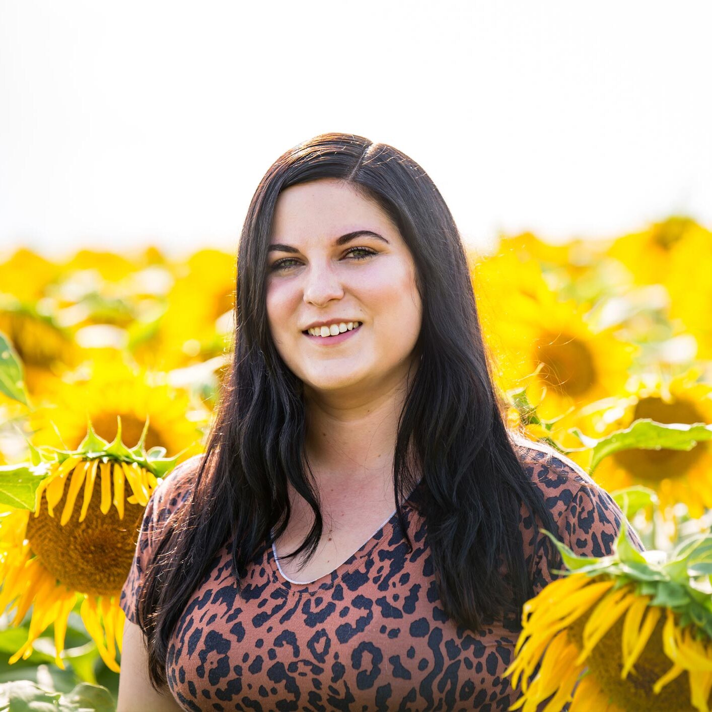 lizzy standing in a sunflower field